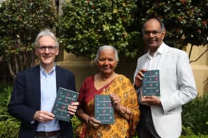 Three adults standing outdoors, each holding a copy of a book titled “The Gender Revolution.” Trees and greenery are visible in the background, symbolizing spiritual growth and echoing themes from the Parable of the Soil.