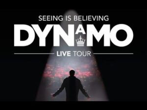 A person stands on stage with arms outstretched under a spotlight, evoking the sense of wonder you might feel watching someone Walk On Water. Text above reads: “Seeing Is Believing Dynamo Live Tour.”.