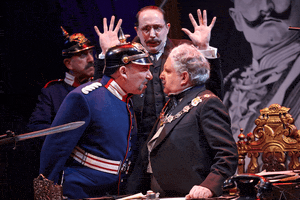 A man in a blue military uniform confronts a man in formal attire at a desk, while another man raises his hands behind them; a large portrait is visible in the background, evoking an atmosphere of tension and reflection reminiscent of spiritual disciplines and the pursuit of spiritual growth.