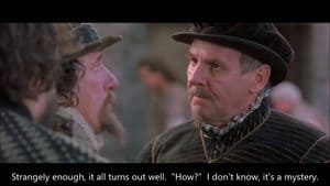 Two men in Renaissance-style clothing converse about the mystery of Christian joys, with subtitles reading: “Strangely enough, it all turns out well. ‘How?’ I don’t know, it’s a mystery.”